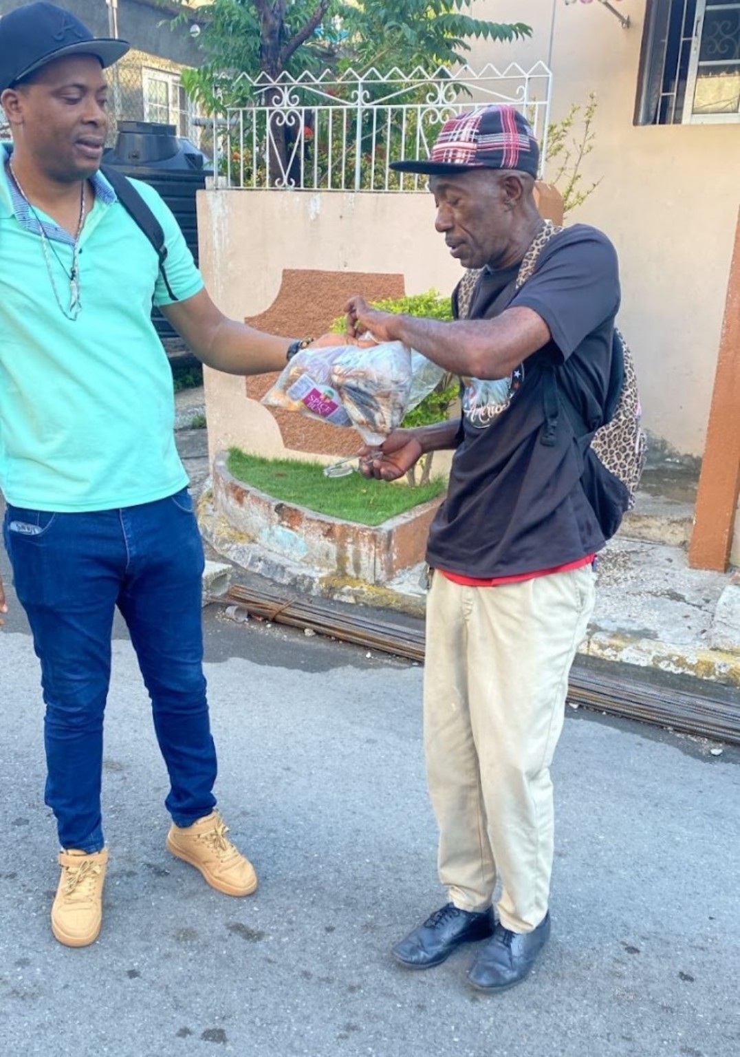 A volunteer giving Easter bun and cheese to a man in Jamaica