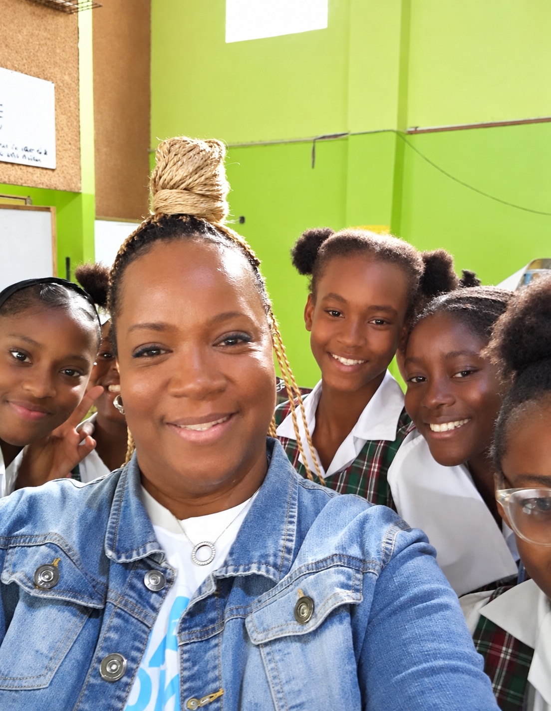 Sandra Wright smiling with students indoors at the 2023 conflict resolution workshop in Jamaica